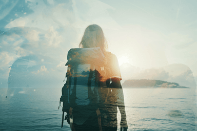 A woman with a backpack standing in front of a body of water
