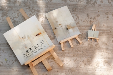 Three Canvas Mockups with Easel on Concrete Surface
