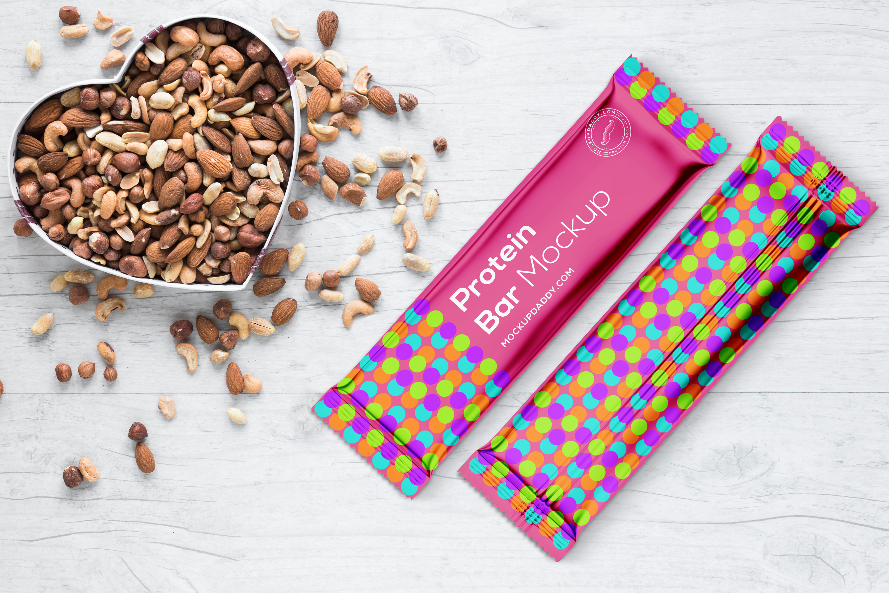 PSD mockup of two protein bars in a bowl with nuts on a wooden table.