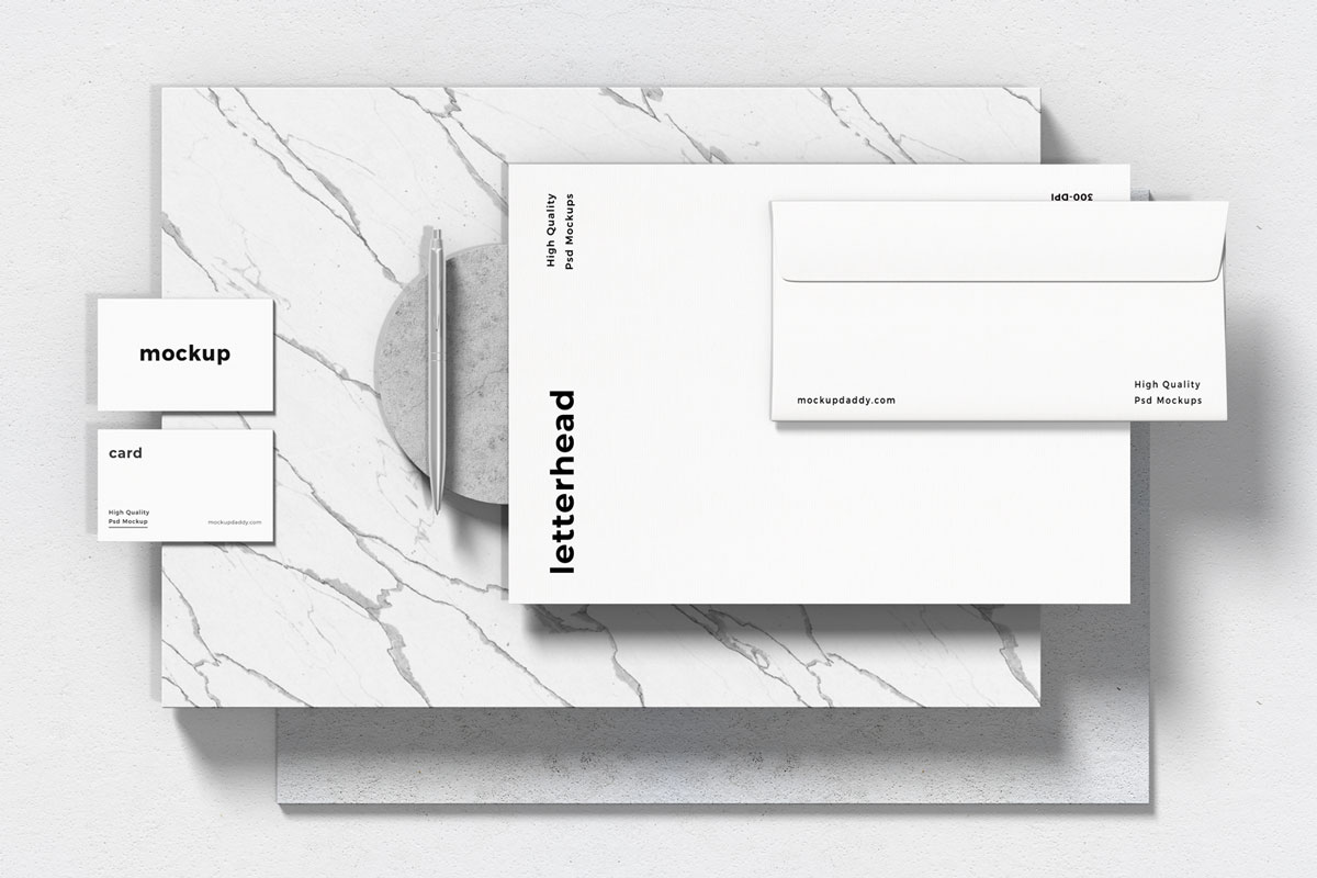 Black and white branding mockup with letterhead, envelope, pen, and business cards