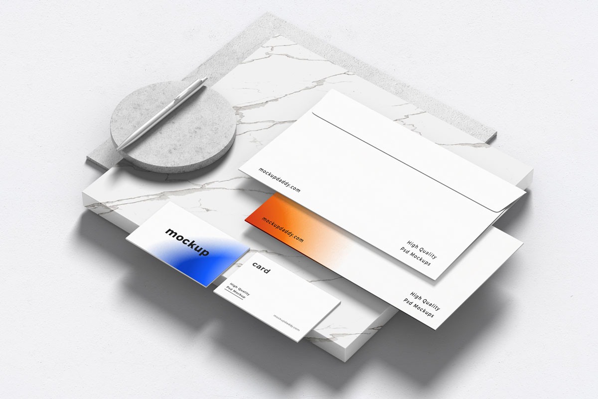 Black and white branding mockup with pen, envelope, and business cards on marble table