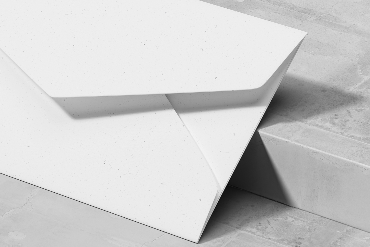 White envelope mockup with black branding design on concrete slab