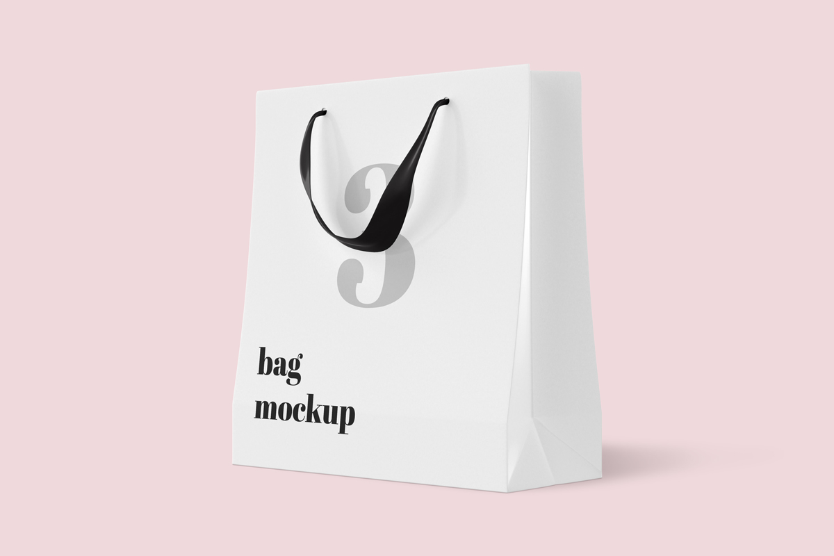 White shopping bag with black handles on pink background.