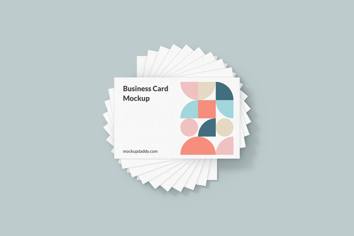 Six business cards with colorful geometric patterns scattered on a table. 