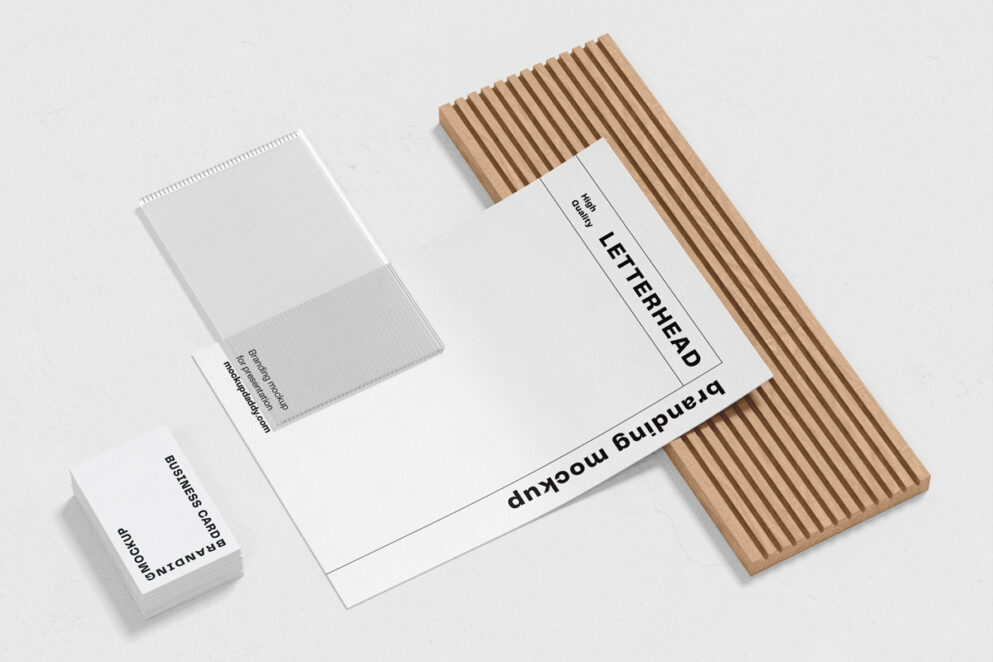 PSD mockup of letterhead, business cards, and envelopes on a wooden shelf. 