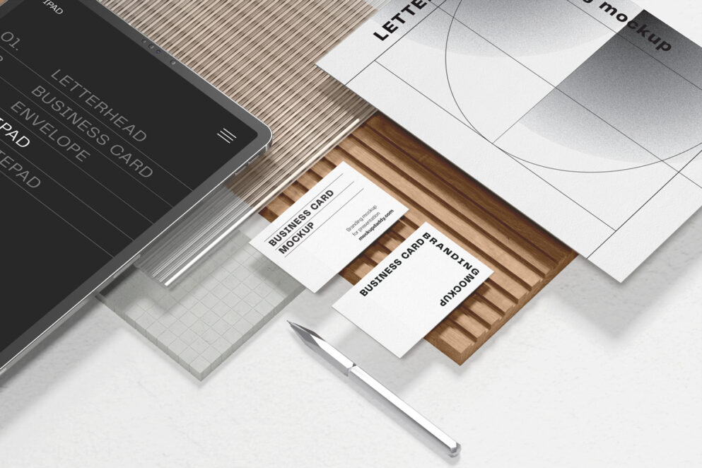 Branding mockup: tablet, business cards, envelope, pen on table.